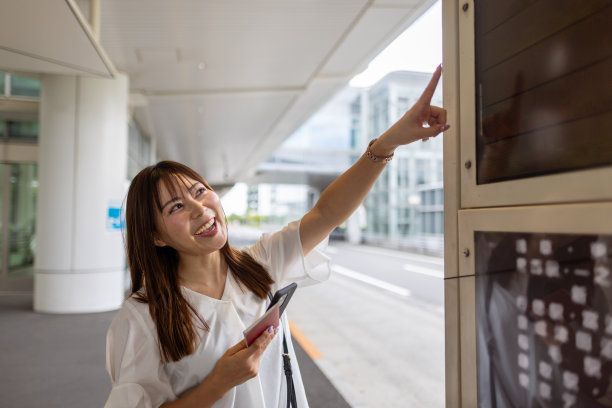 女游客在机场巴士终点站指向目的地图片下载
