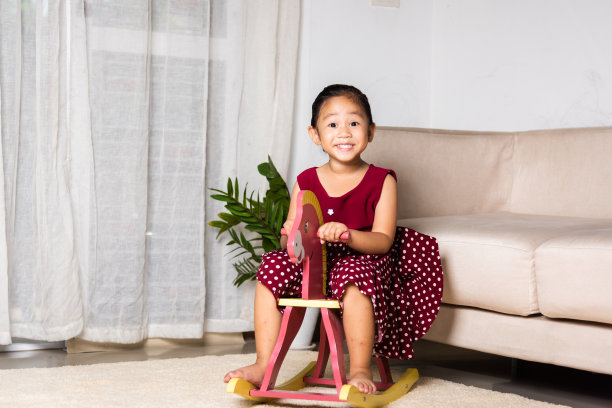 亚洲可爱的小女孩荡秋千骑玩具马图片下载