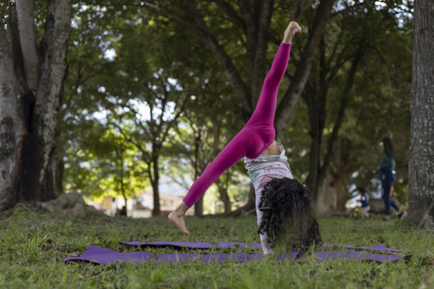 拉丁美洲女孩在公园里玩得很开心，灵巧地做体操。图片下载