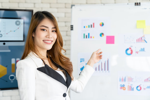 亚洲女商人在办公室向公司同事展示商业计划。在现代办公室里，亚洲女商人在写字板上向她的合伙人展示战略计划。图片下载