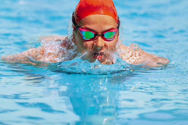 活泼的女人，游泳运动员戴着游泳帽和护目镜在开放的公共游泳池训练。度假，积极的生活方式，动力，能量，运动的运动理念。图片下载