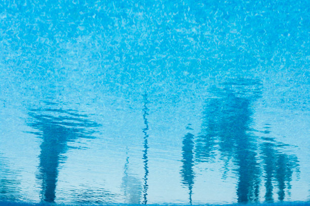 美丽的蓝色水背景与抽象的倒影。图片下载