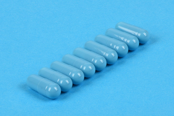 蓝色背景的蓝色医疗胶囊高分辨率的照片。图片下载