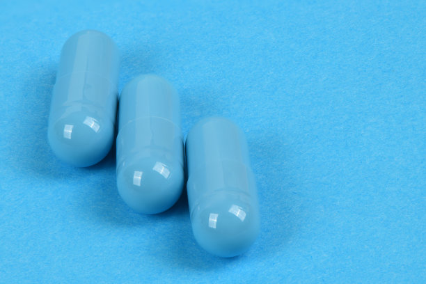 蓝色背景的蓝色医疗胶囊高分辨率的照片。图片下载