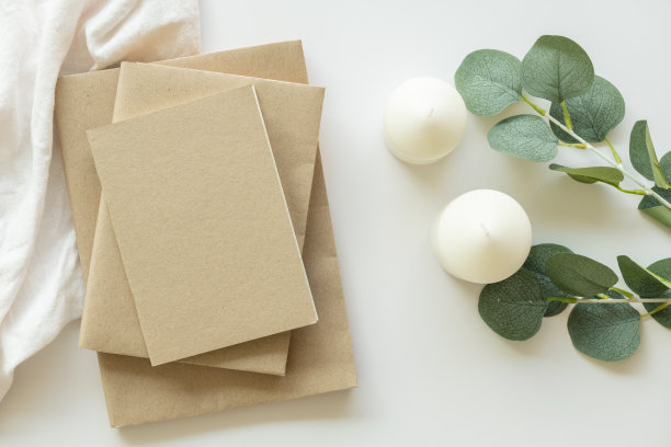 创意平面照片的工作空间办公桌。顶视图办公桌与模型书，白色背景香薰蜡烛。工作空间的概念。俯视图，复制空间，模型，平面布局。图片下载