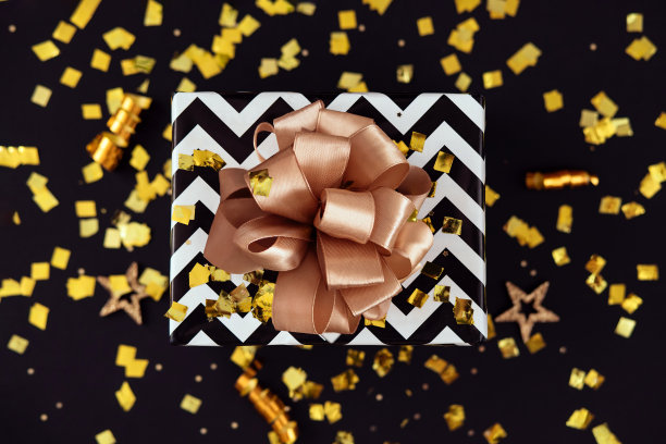 礼品盒与节日五彩纸屑的黑色背景，俯瞰图片下载