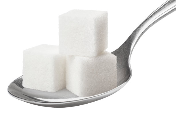 方糖放在白色的金属勺上图片下载