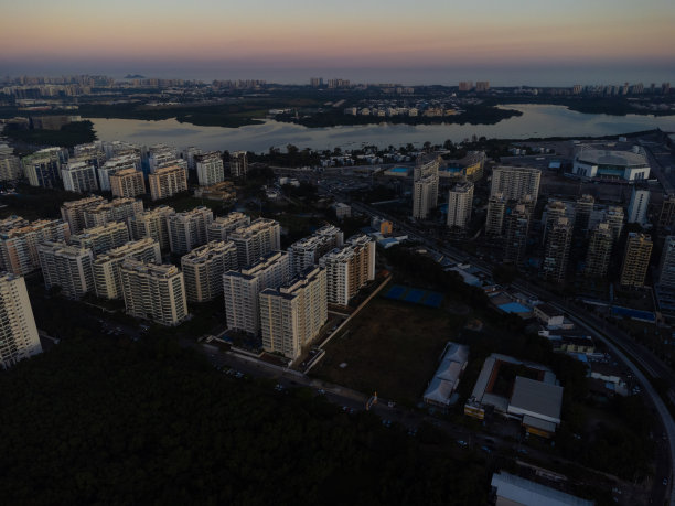 鸟瞰Jacarépagua泻湖在里约热内卢de Janeiro，巴西。住宅建筑和群山环绕着湖泊。背景是巴拉达蒂茹卡海滩。阳光明媚的一天。日落。无人驾驶飞机的照片图片下载