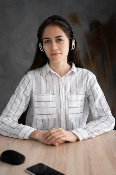 年轻的西班牙裔女性肖像在耳机看摄像头有网络摄像头数字虚拟事件。女性戴着耳机在视频通话。沟通图片下载