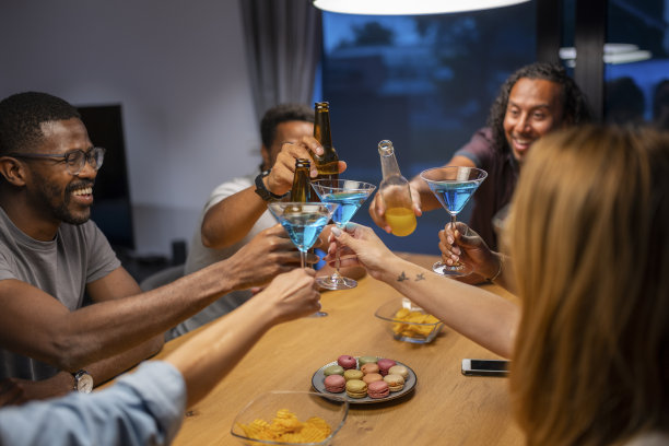 在一个炎热的夏夜，在新房子里与快乐的朋友举杯。国际多元化的民族。图片下载