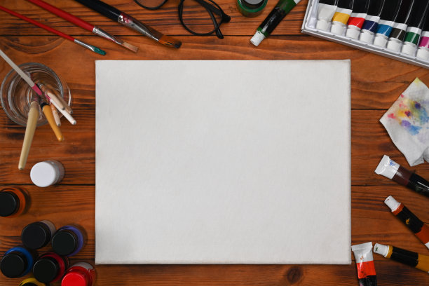 在木桌上俯视一张白纸和艺术用品。艺术家工作空间，为您的艺术或演示文稿复制空间。图片下载