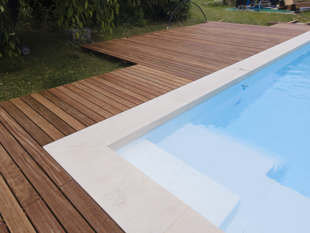 无人机在美丽的绿色花园和游泳池上空飞行，游泳池的木制甲板正在进行，泳池机器人正在工作图片下载