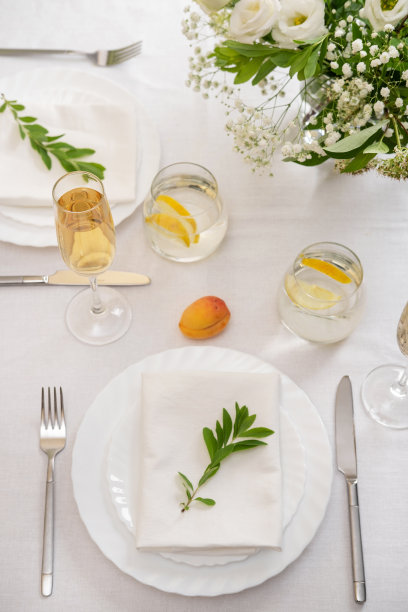 婚礼餐桌装饰用白花，眼镜和白色餐巾。婚宴上装饰优雅的餐桌。节日的餐桌布置。婚礼的装饰。图片下载