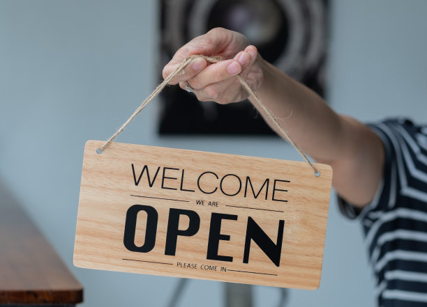 女人持有开放的标签与模糊的背景图片下载