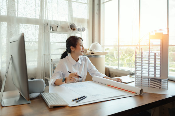 选择重点，亚洲女性建筑师或工程师绘制设计蓝图中的建筑结构。亚洲女性建筑师或工程师坐在办公室里分析、设计项目。图片下载