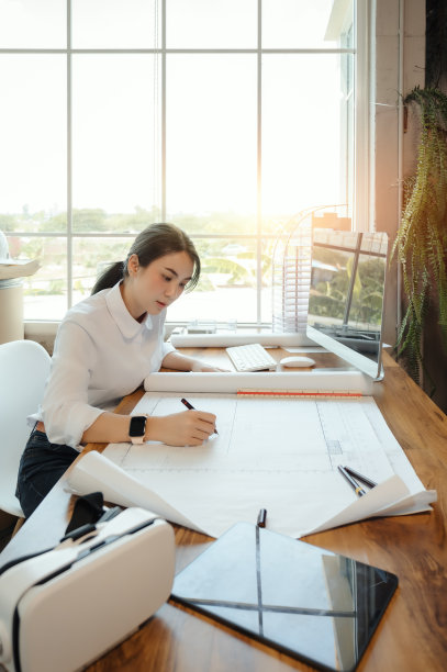 选择重点，亚洲女性建筑师或工程师绘制设计蓝图中的建筑结构。亚洲女性建筑师或工程师坐在办公室里分析、设计项目。图片下载