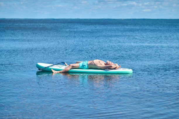 男子躺在水上的划艇上图片下载