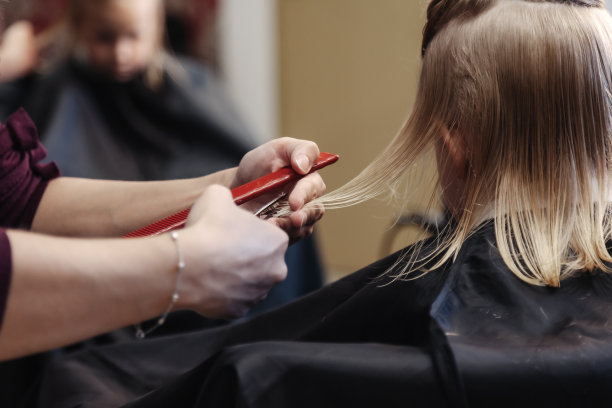 理发师为可爱的小女孩做时髦漂亮的发型图片下载