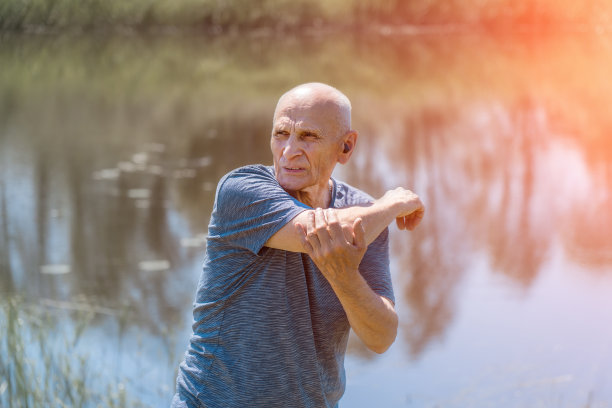 白发苍苍的老人在公园里做体操。图片下载