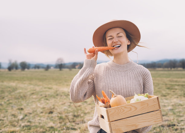 妇女与当地有机食品的农田地区。在当地农贸市场的户外，顾客或农民带着一箱蔬菜。不使用塑料的可持续购物。中小企业的概念。图片下载