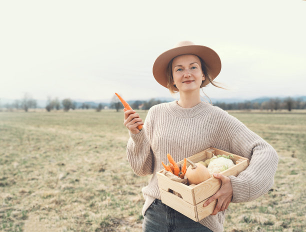 妇女与当地有机食品的农田地区。在当地农贸市场的户外，顾客或农民带着一箱蔬菜。不使用塑料的可持续购物。中小企业的概念。图片下载