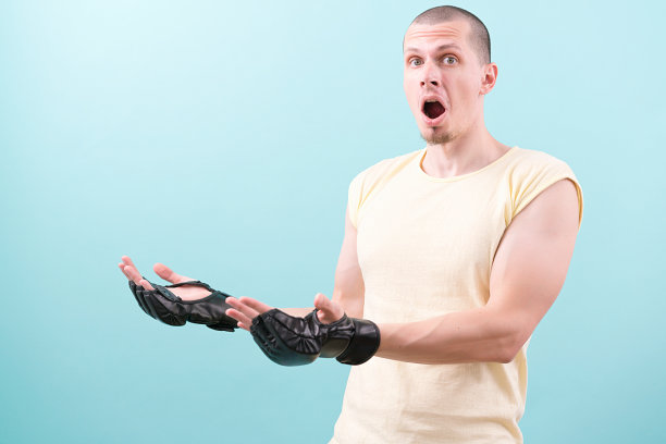 一个戴着黑色手套、穿着黄色衬衫的综合格斗选手站在蓝色背景上，两只手放在复制空间上。冠军。张开嘴。战斗。战斗。战斗。运动员。武术图片下载