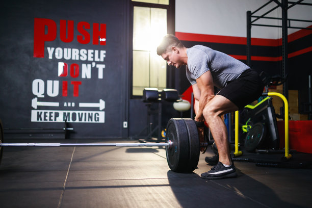 运动员在健身房举杠铃。侧视图。健身和运动理念图片下载