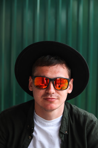 微笑着时尚的人。英俊微笑时尚潮人的肖像lambersexual模型。男子穿着红色偏振太阳镜和帽子。现代背景下的时尚男性。高加索人图片下载