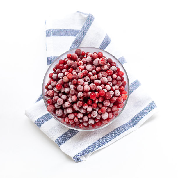 冰冻森林越橘在玻璃碗上的条纹餐巾在白色。前视图。广场的照片。图片下载