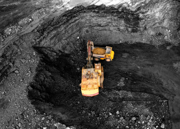 露天采煤。采石场，挖掘机在运输卡车上装载煤炭。图片下载