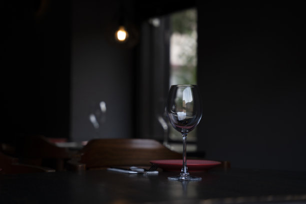 酒杯和餐盘摆放在黑色背景前图片下载