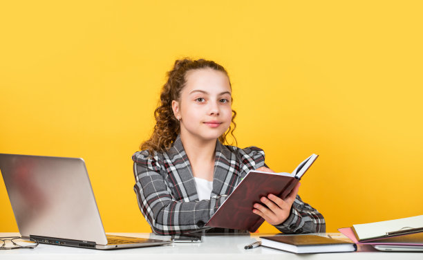 做笔记。回到学校。时间学习。小女孩在办公室。小商人。快乐的童年。卷头发的孩子穿夹克。在笔记本电脑工作。女学生有在线作业图片下载