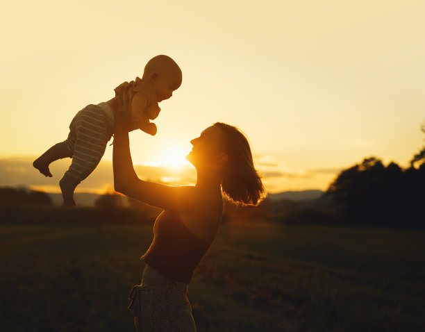 夕阳下慈爱的母亲和婴儿。大自然中美丽的女人和小孩。自然母性的概念。幸福健康的家庭在夏天户外。积极的人类情绪和感觉。图片下载