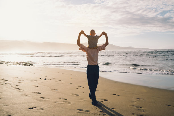 妈妈和孩子一起在海滩上玩耍，玩得很开心。幸福的家庭在户外。妈妈和宝宝在夏天上大自然。积极的人类情绪和感觉。一家人在海边度假。图片下载