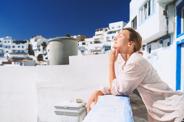 年轻女子在加那利群岛度暑假。欧洲旅行。旅游女孩在白色建筑的老地道的渔业小镇图菲亚(像希腊的圣托里尼)在大加那利岛，西班牙。图片下载