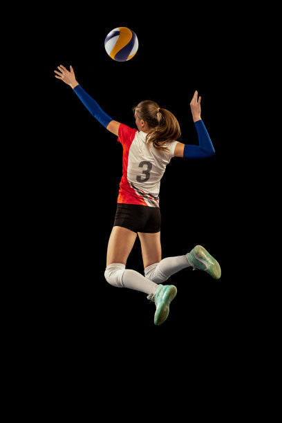 动态肖像的职业排球运动员在运动制服打排球孤立在黑暗的背景。运动，健康的生活方式，团队，行动，运动概念图片下载