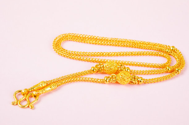 金色项链在粉红色的背景。图片下载