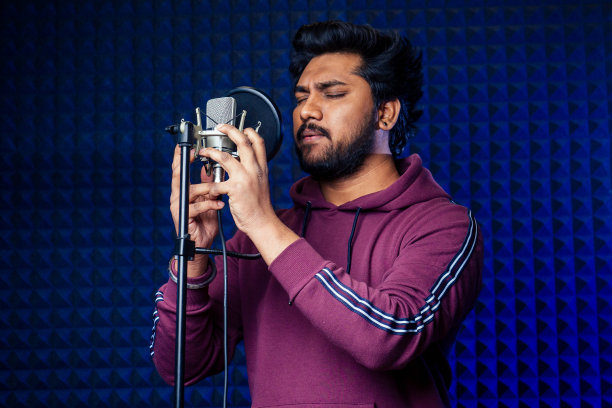 专业演唱印度男子耳机声音现代录音棚紫罗兰背景录音歌曲。图片下载