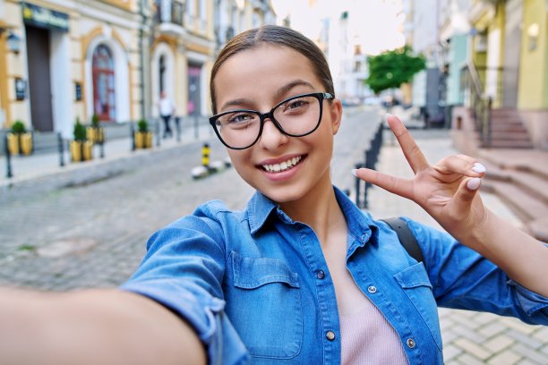 美丽开朗的少女自拍肖像，户外的城市街道图片下载