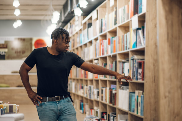 在图书馆或书店挑选和阅读书籍的非裔美国人图片下载