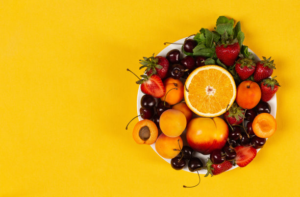 明亮的黄色底色，盛满成熟的水果和浆果图片下载