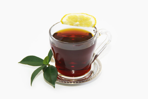 红茶在一个透明的杯子，一片柠檬和绿叶图片下载