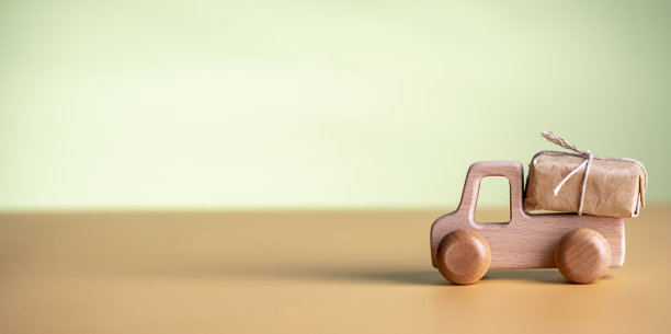 木制汽车与包或礼品与空间的文字。理念快递、假期、生态。图片下载