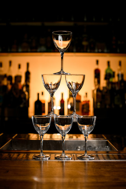 吧台空玻璃杯金字塔的正面视图。模糊的背景图片下载