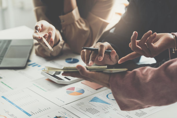 一群在工作场所工作的商务人士。业务团队的手工作与财务计划，会议，讨论，头脑风暴与平板电脑的办公桌。图片下载