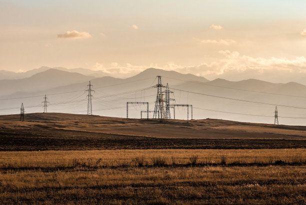 夕阳下沙漠中的高压塔图片下载