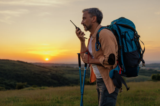 徒步旅行者在山上休息时用收音机讲话图片下载