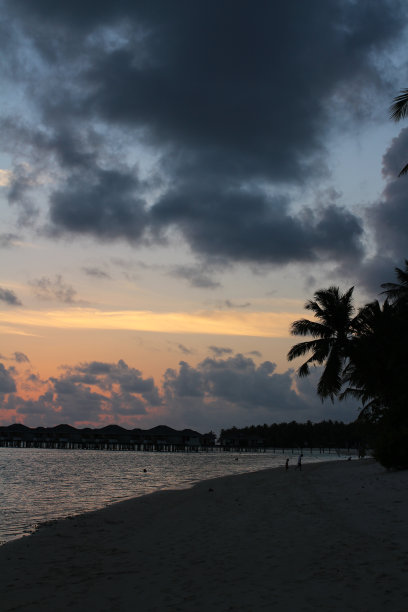 马尔代夫的日落，夕阳西下，映衬着印度洋水面上踩高跷的别墅。图片下载
