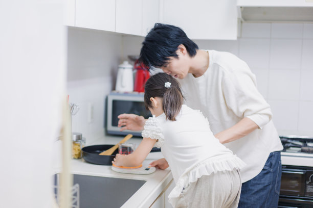 一个小女孩和她爸爸一起做饭图片下载