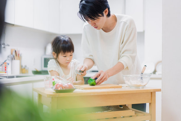 一个小女孩和她爸爸一起做饭图片下载